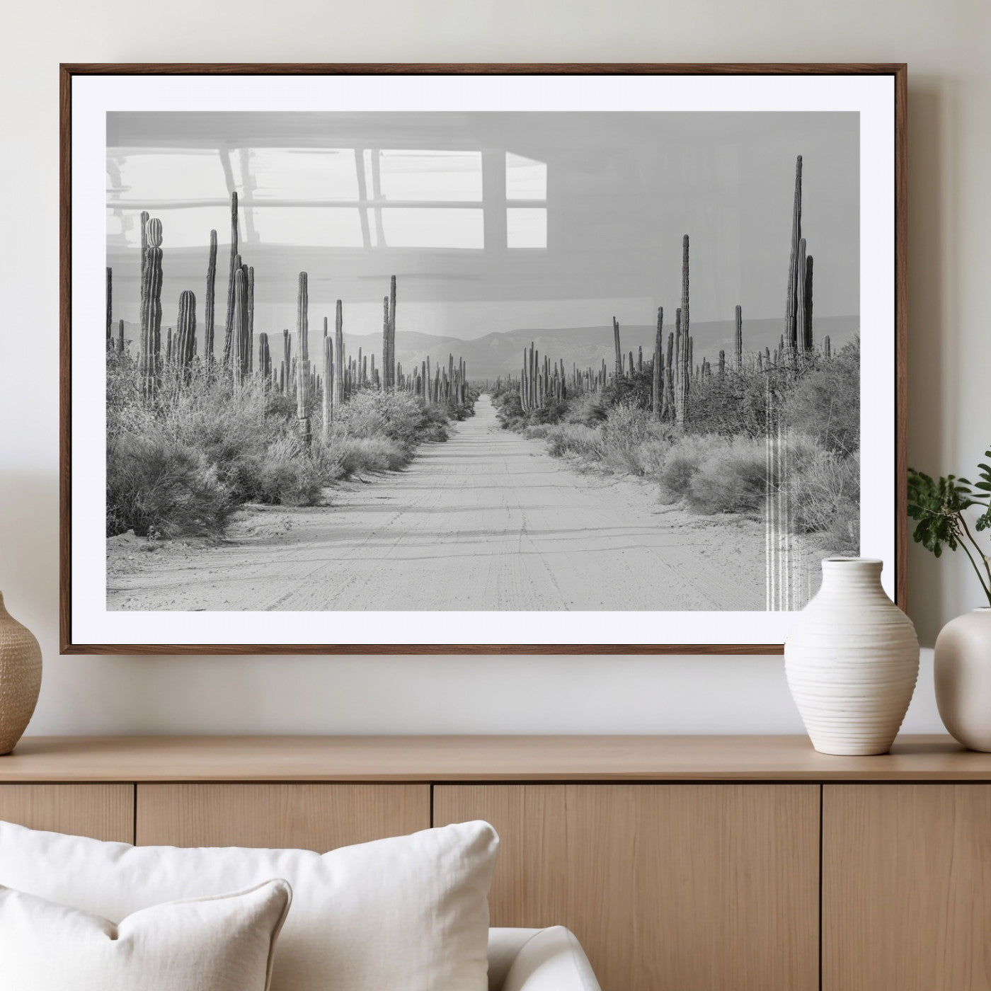 A black and white desert road stretching through a cactus-filled landscape, creating a rugged and timeless southwestern aesthetic with a sense of adventure.