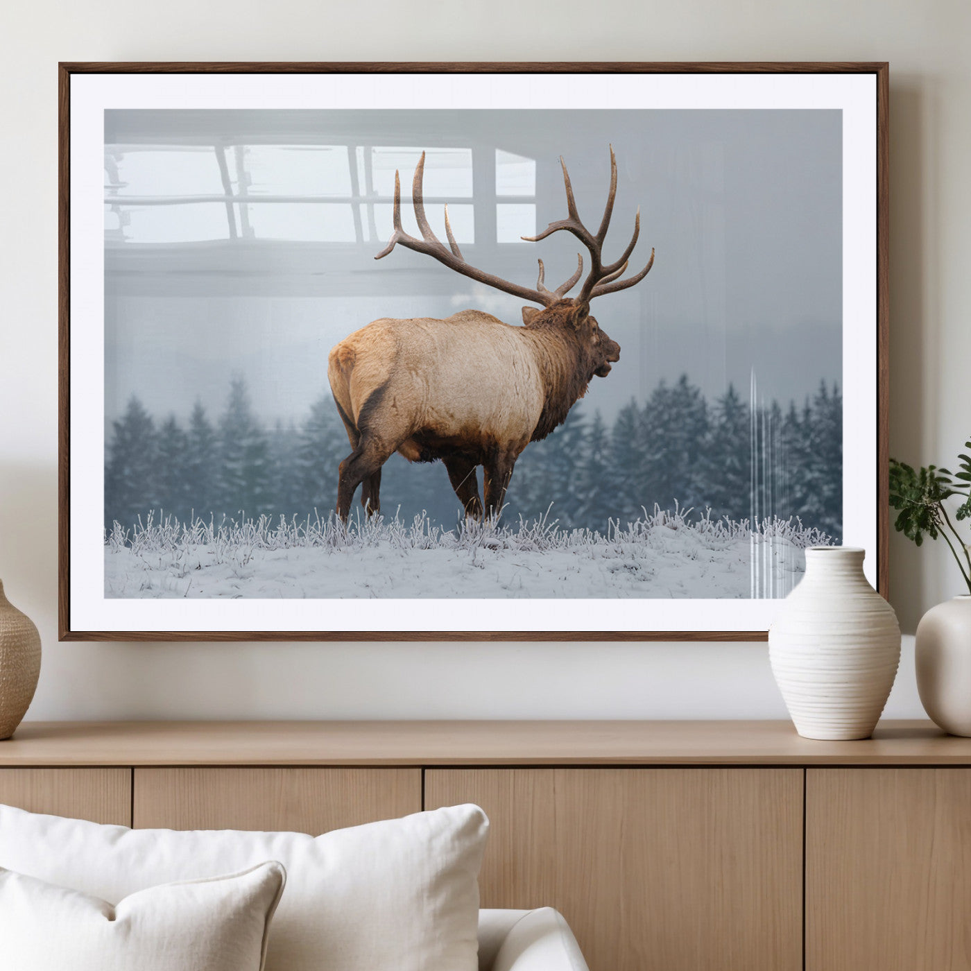 Large elk standing in a snowy field with pine trees in the background, ideal for rustic cabin or lodge-style wall decor.