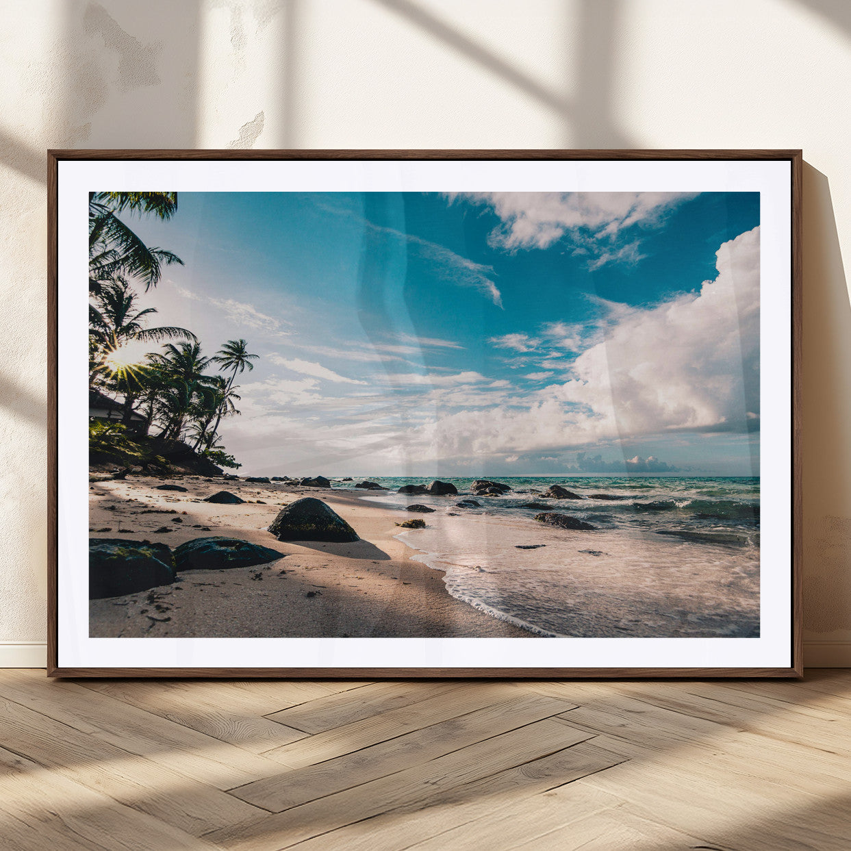 Scenic tropical beach with palm trees, ocean waves, and rocky shoreline under a bright blue sky, creating a serene coastal vibe.