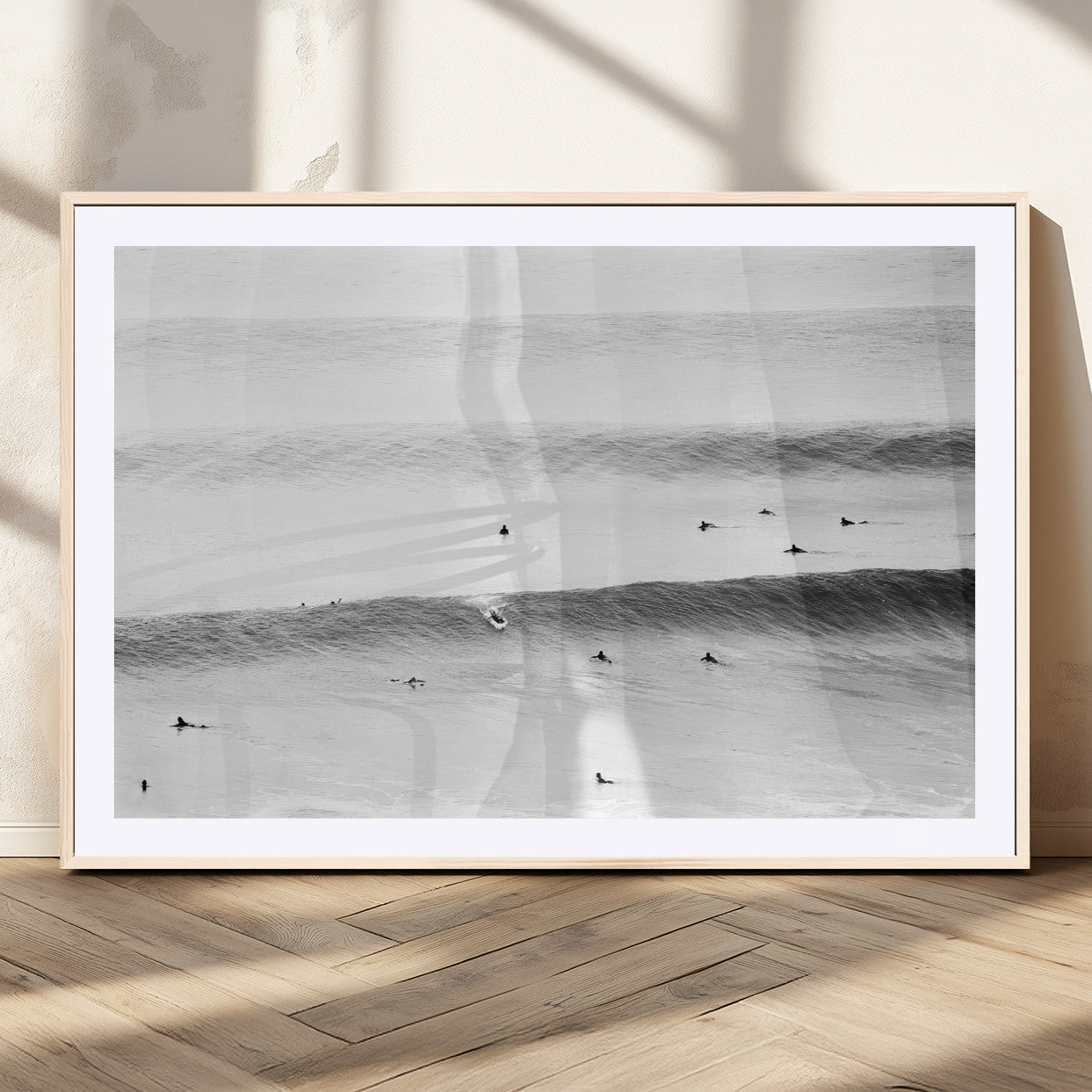 A monochrome photograph of swimmers gliding through gentle ocean waves, evoking a sense of calm and movement.