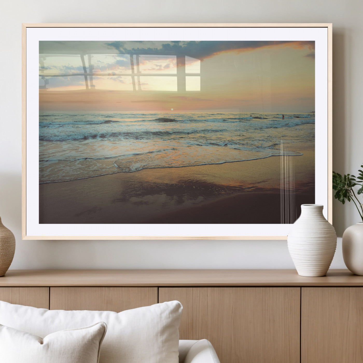 Warm sunset over gentle ocean waves with pastel sky and reflections on wet sand, creating a calm and soothing beach ambiance.