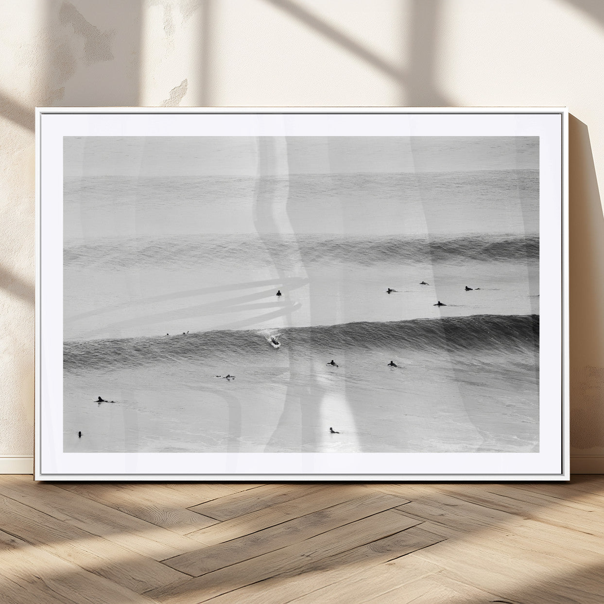 A monochrome photograph of swimmers gliding through gentle ocean waves, evoking a sense of calm and movement.