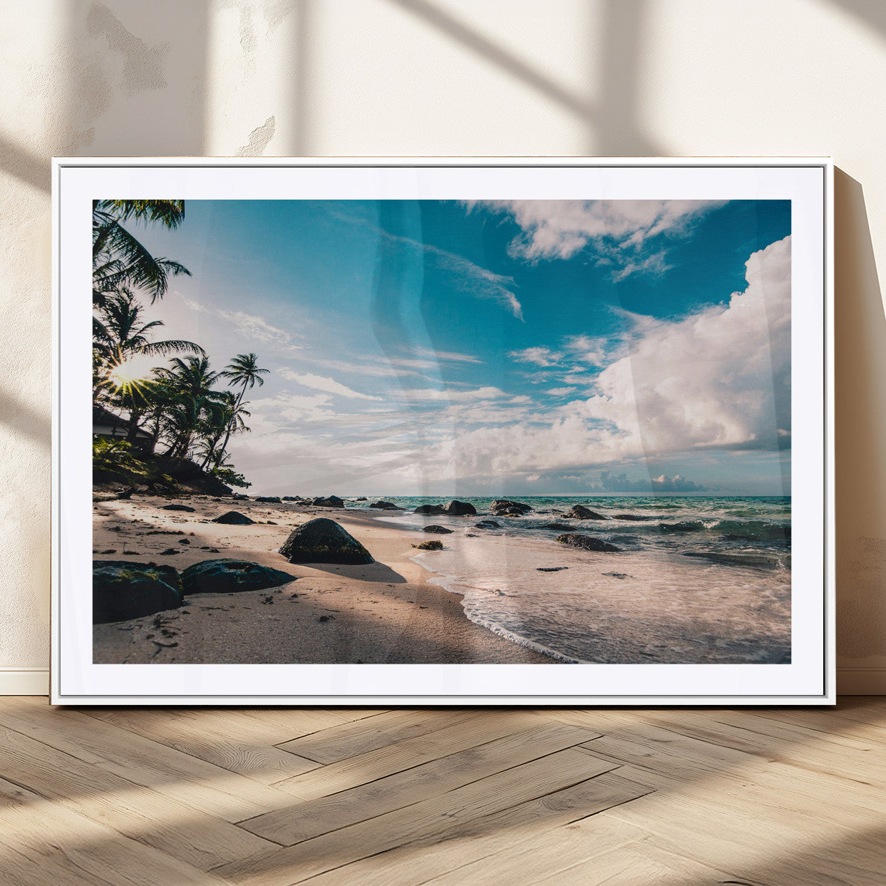 Scenic tropical beach with palm trees, ocean waves, and rocky shoreline under a bright blue sky, creating a serene coastal vibe.