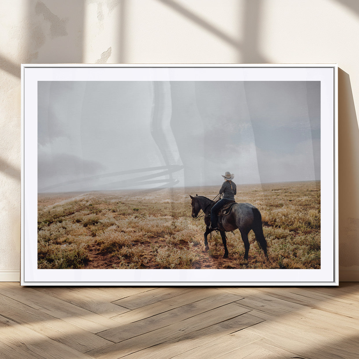 A lone cowboy riding horseback across an open prairie under a vast sky, capturing the rugged and timeless spirit of the Western frontier.