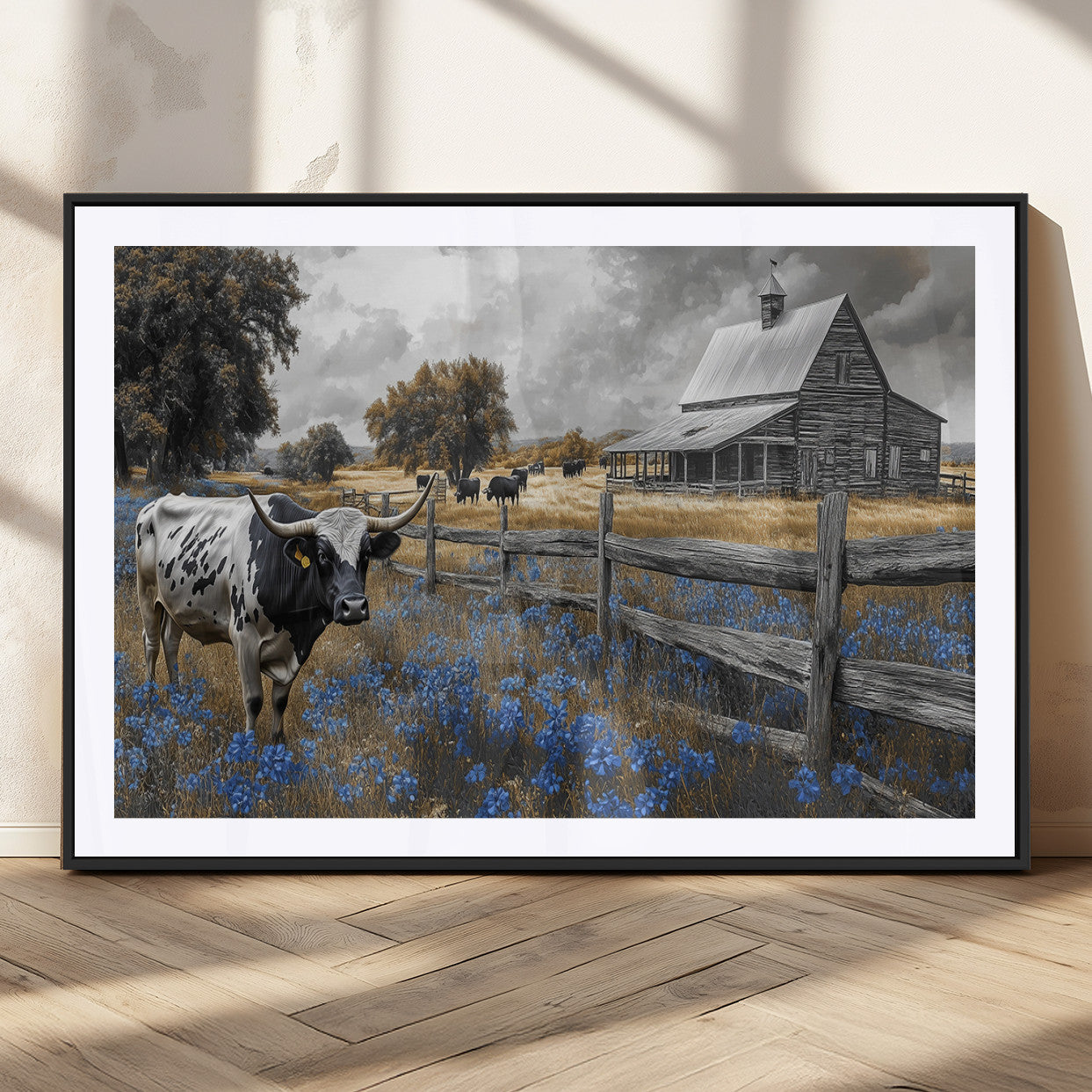 A Texas longhorn stands in front of a rustic barn and wooden fence, with bluebonnets and grazing cattle under dramatic skies.