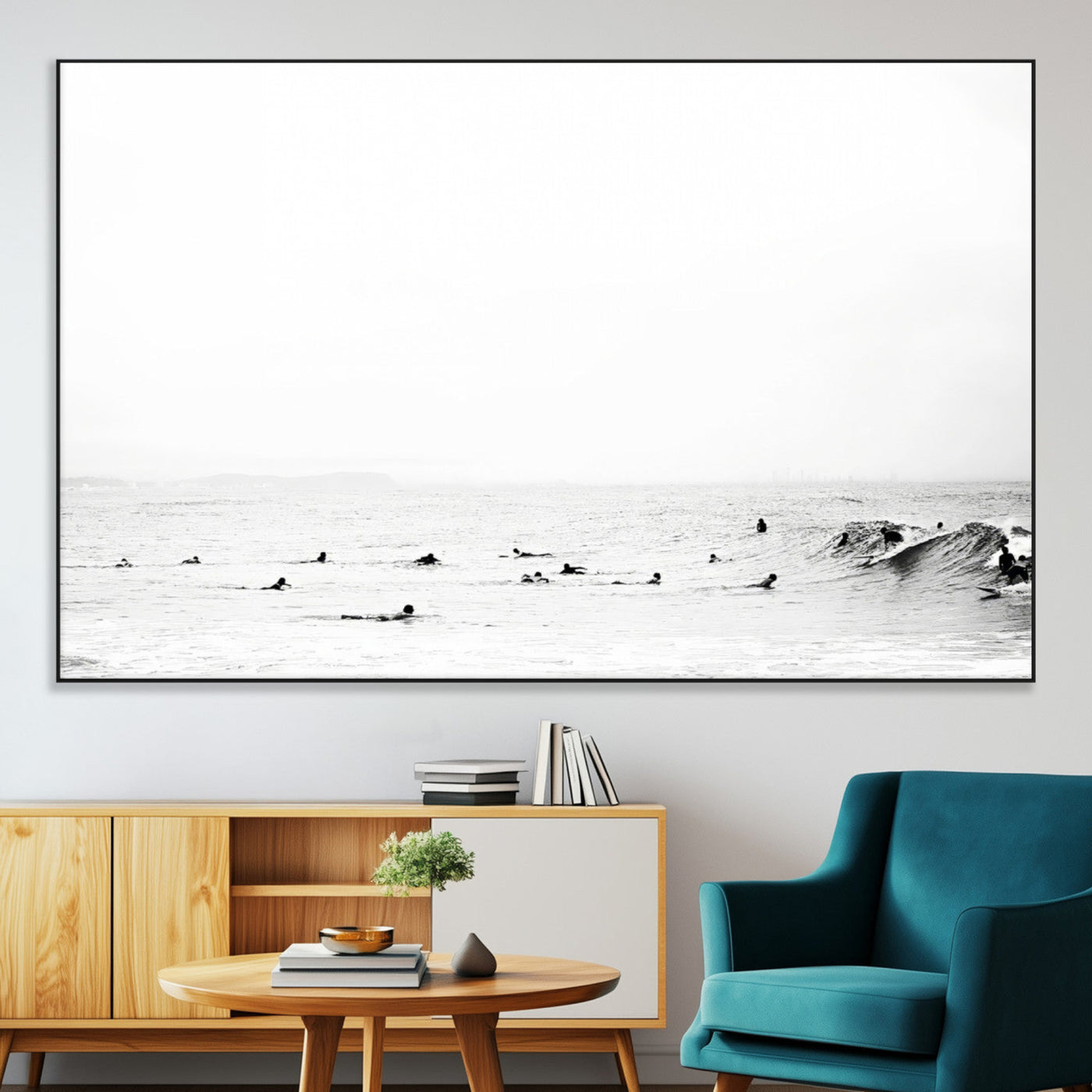 A group of surfers floating in the ocean, waiting for waves under a vast, moody sky, captured in black and white.