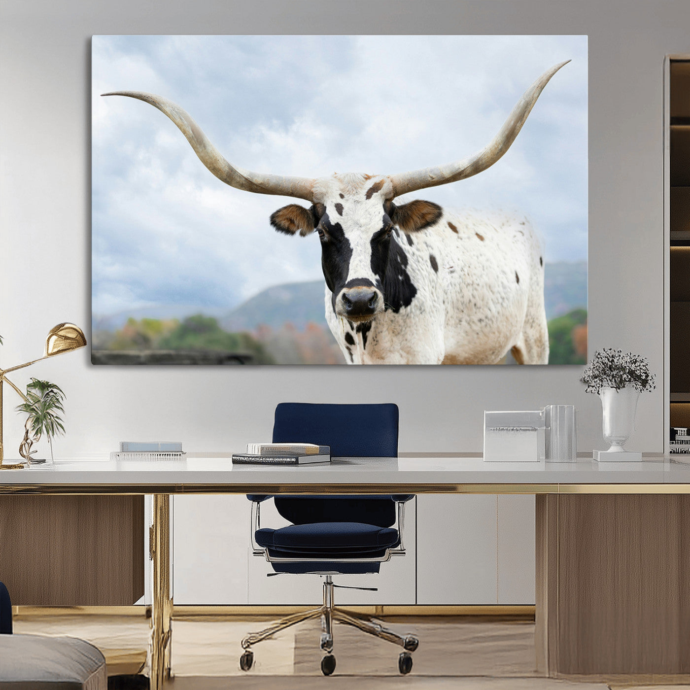 Close-up of a Texas Longhorn with curved horns, black and white markings, set against a cloudy sky and distant hills, perfect for rustic decor.