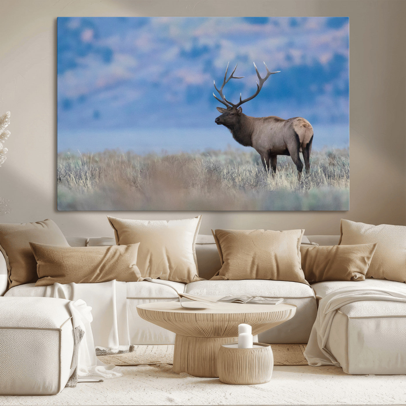 Elk with large antlers standing in open field, mountains blurred in background, perfect for rustic cabin or lodge-style decor.