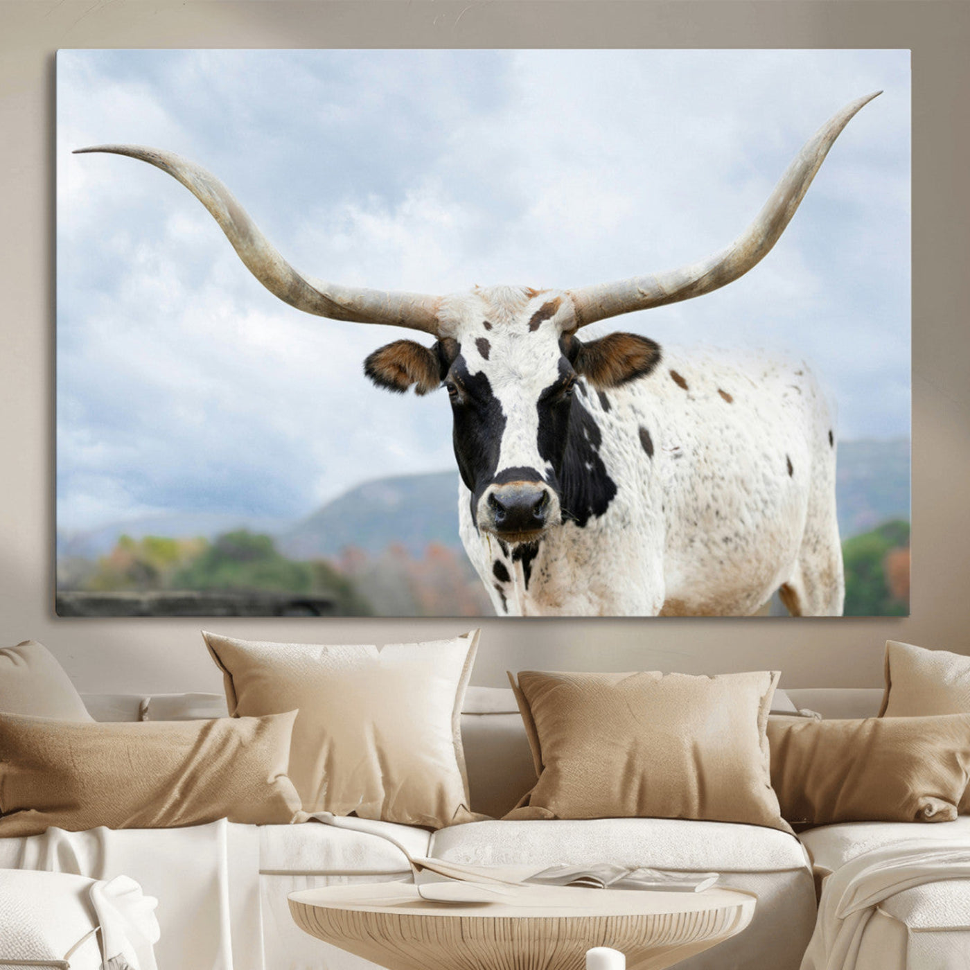 Close-up of a Texas Longhorn with curved horns, black and white markings, set against a cloudy sky and distant hills, perfect for rustic decor.