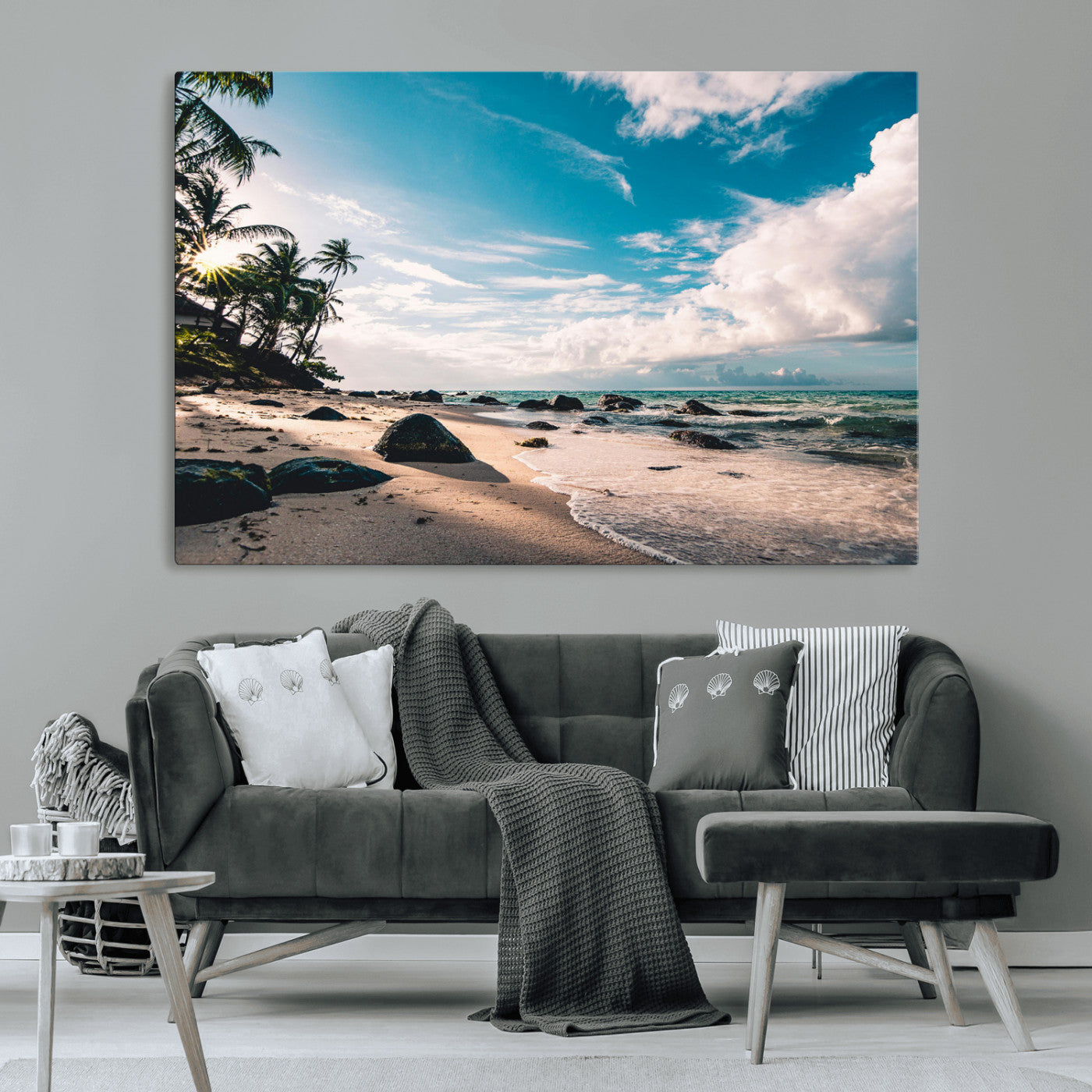 Scenic tropical beach with palm trees, ocean waves, and rocky shoreline under a bright blue sky, creating a serene coastal vibe.