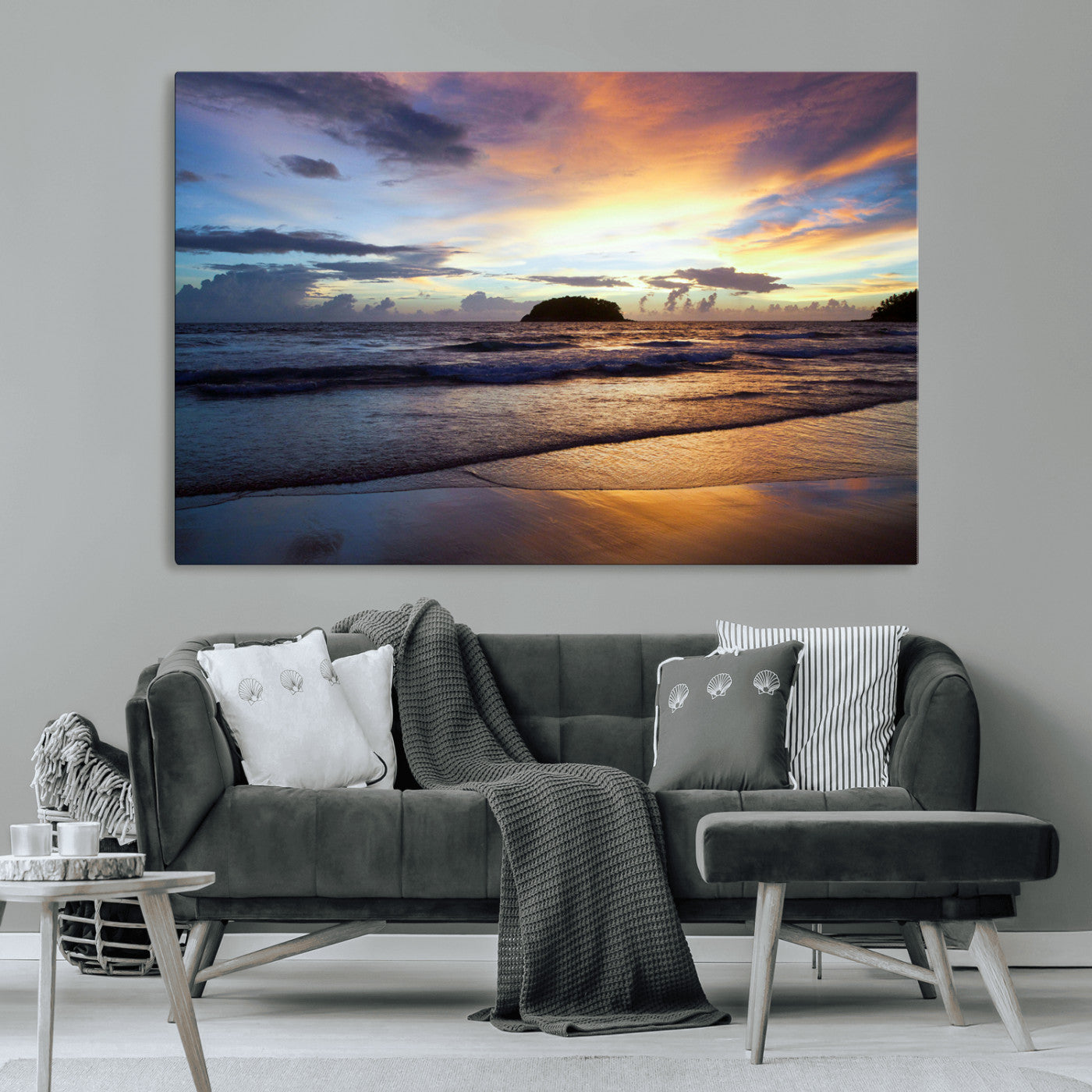 A tropical beach at sunset with waves gently washing ashore, reflecting golden and purple hues in the sky, creating a tranquil coastal scene.