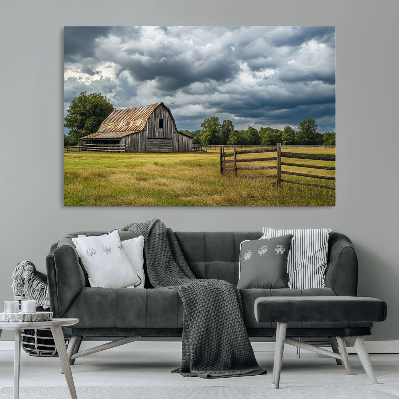 "Rustic barn in a wide open field under a dramatic sky with dark clouds, surrounded by a wooden fence and lush green trees."