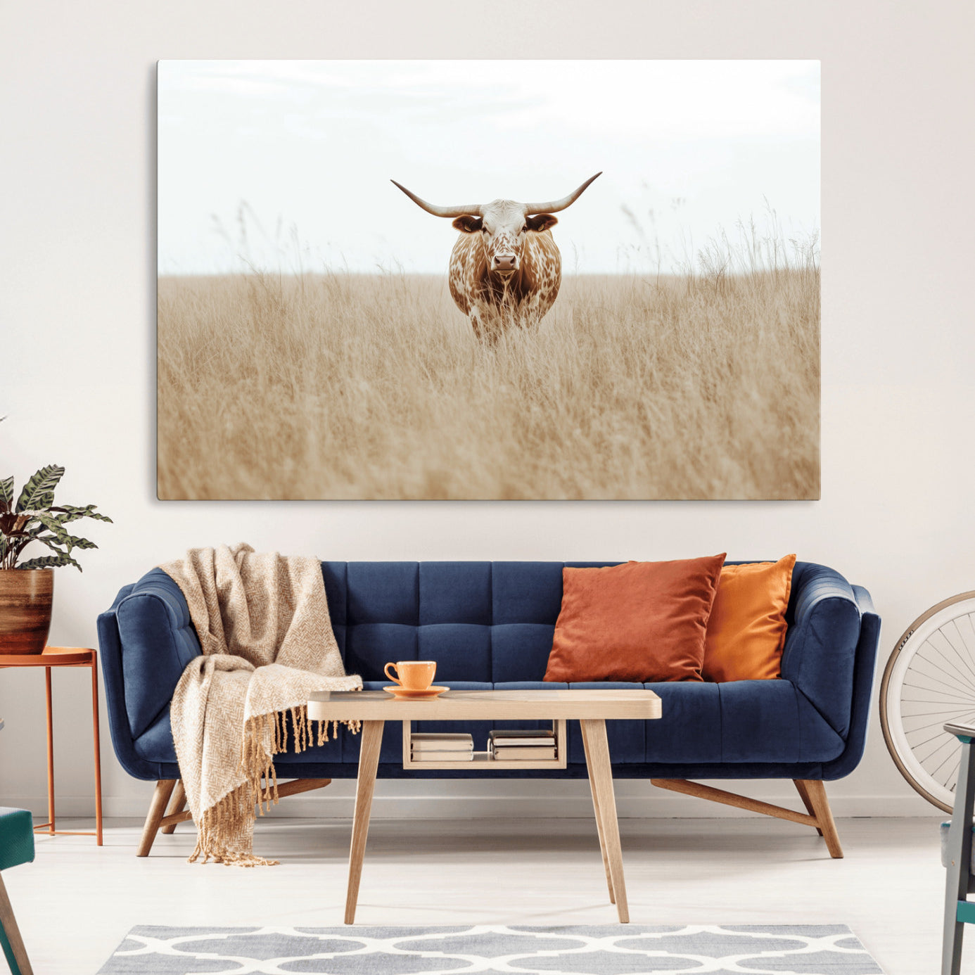 Texas Longhorn bull standing alone in dry grass with neutral tones, ideal for rustic western or cowboy-themed wall decor.