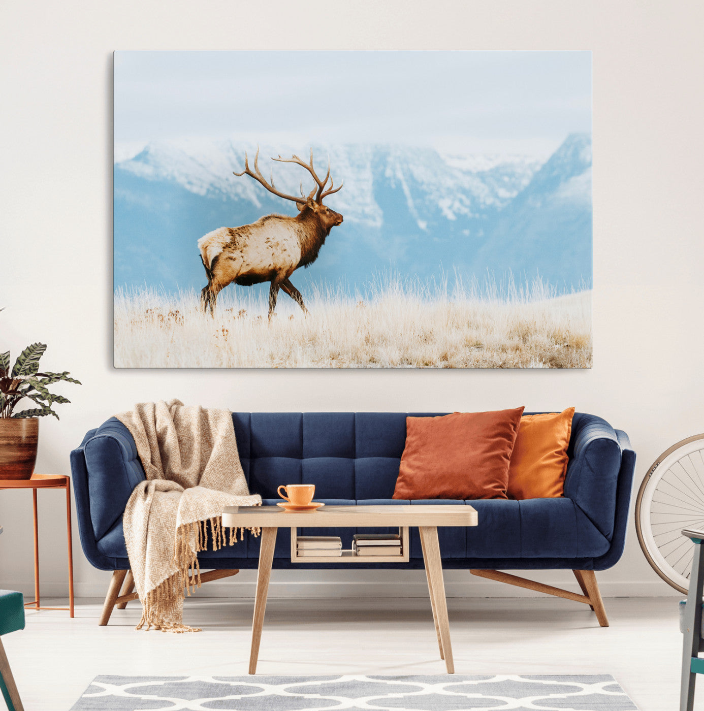 Majestic elk with antlers walking on golden grass, snowy mountains behind, perfect for rustic lodge or Scandinavian decor.