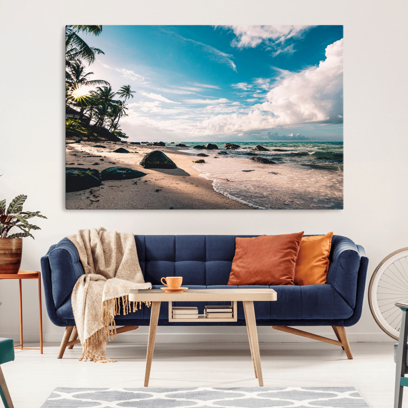 Scenic tropical beach with palm trees, ocean waves, and rocky shoreline under a bright blue sky, creating a serene coastal vibe.