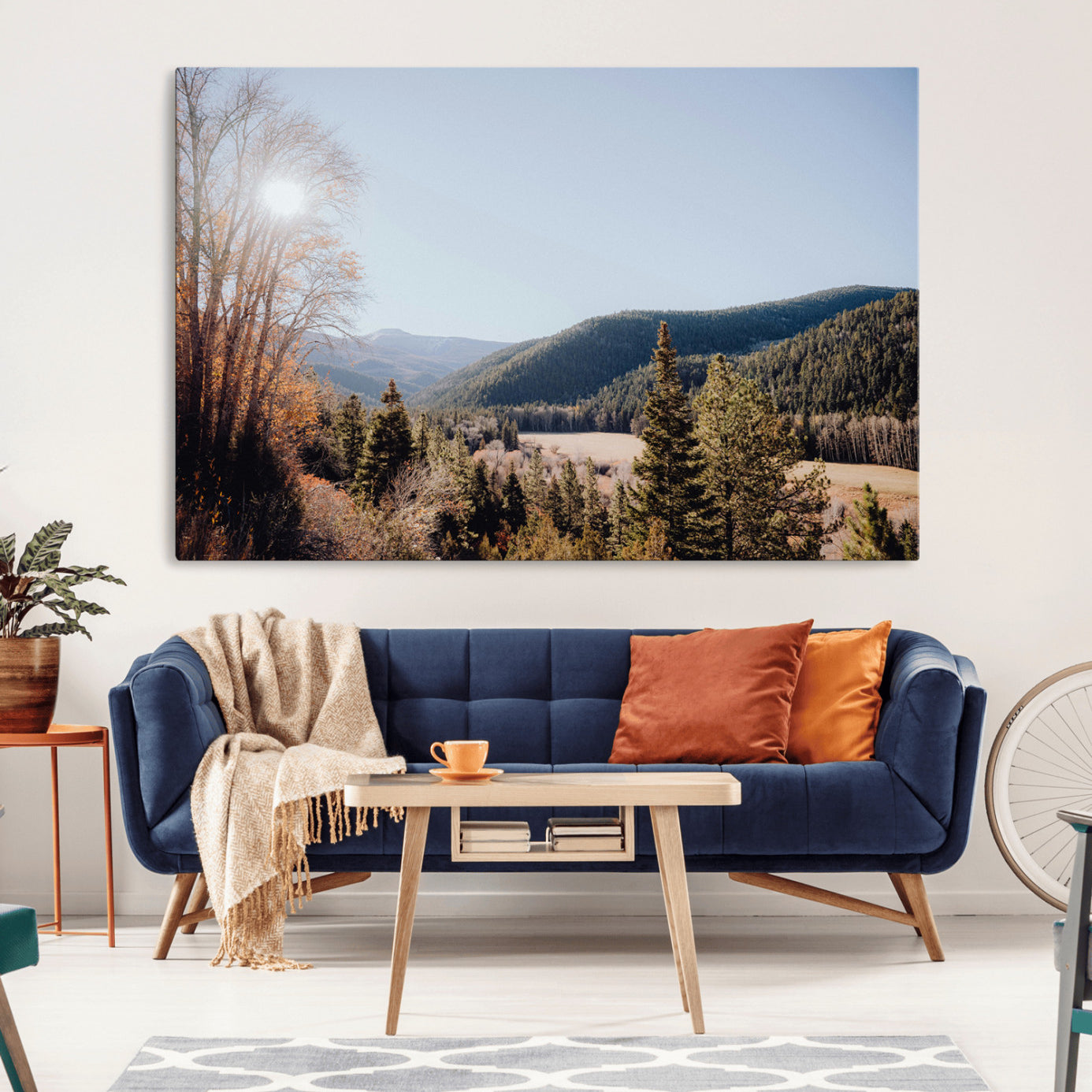 A scenic mountain valley with pine trees and autumn foliage under a clear sky, bathed in golden sunlight, creating a peaceful and rustic landscape.