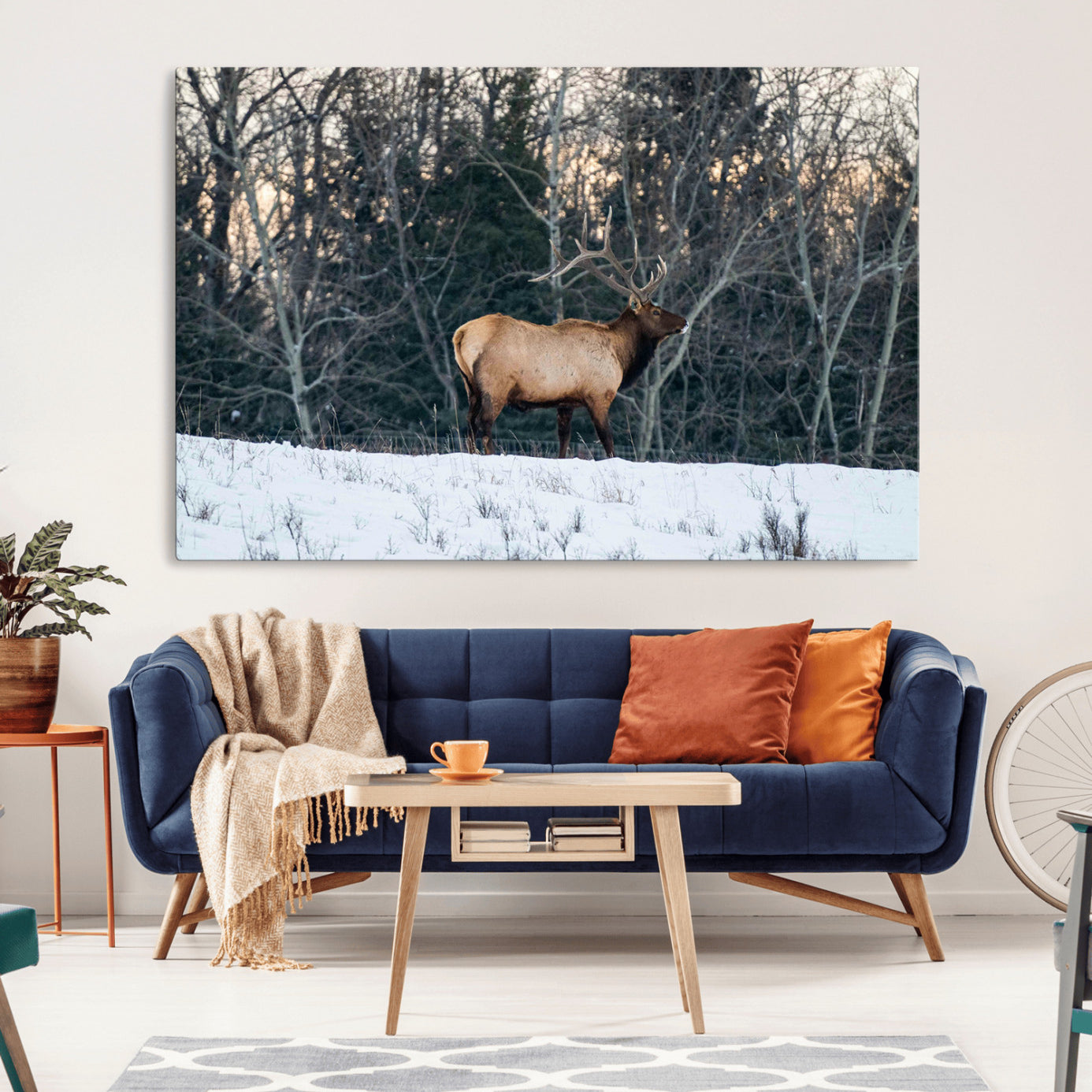 A majestic elk with large antlers standing in a snowy field against a winter forest backdrop, perfect for rustic and wildlife-themed home decor.
