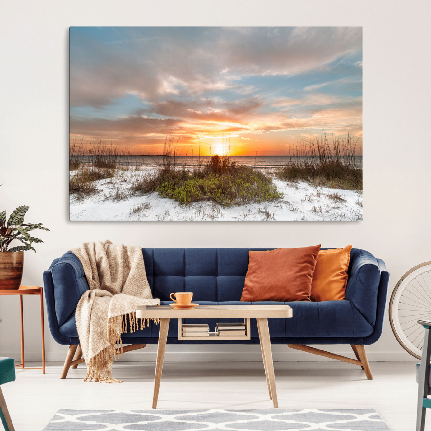 A tranquil beach scene featuring golden sunset hues over the water, with grasses in the foreground and a peaceful, serene atmosphere.