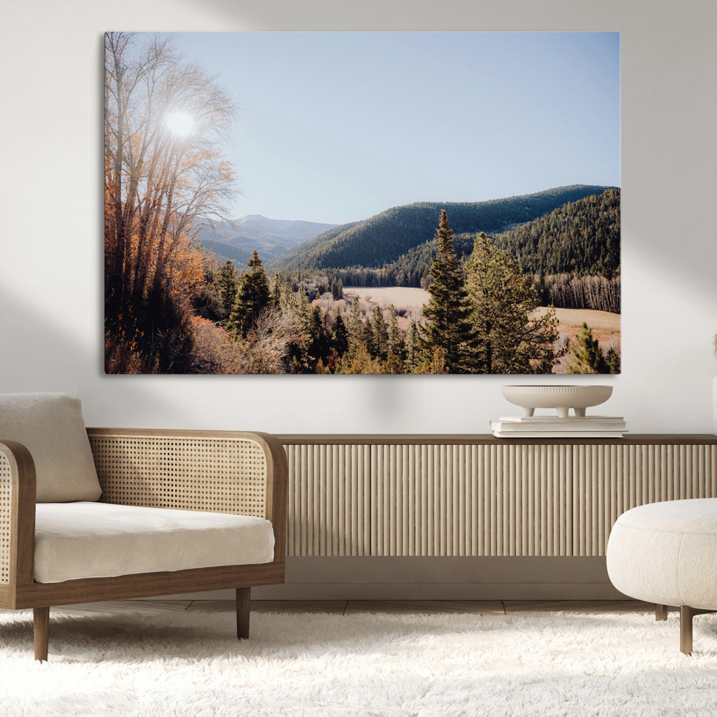 A scenic mountain valley with pine trees and autumn foliage under a clear sky, bathed in golden sunlight, creating a peaceful and rustic landscape.