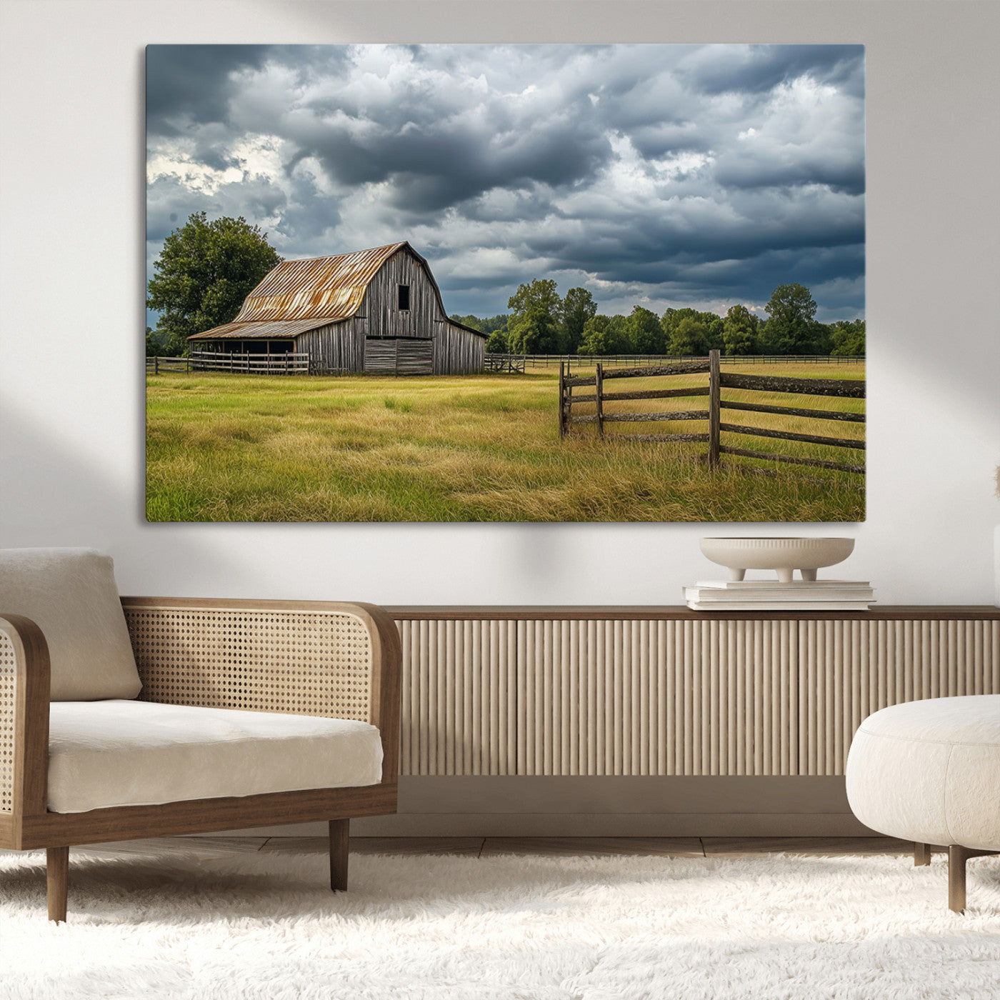 "Rustic barn in a wide open field under a dramatic sky with dark clouds, surrounded by a wooden fence and lush green trees."
