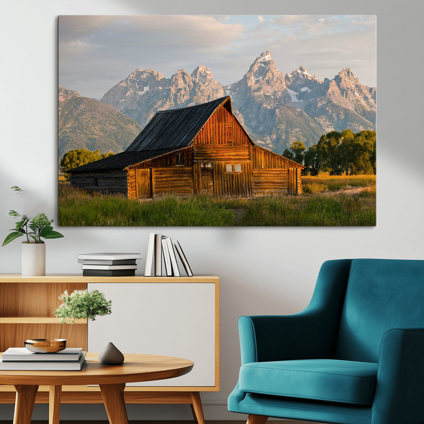 Rustic wooden barn set against towering mountain peaks under warm golden light, creating a peaceful Western countryside scene.