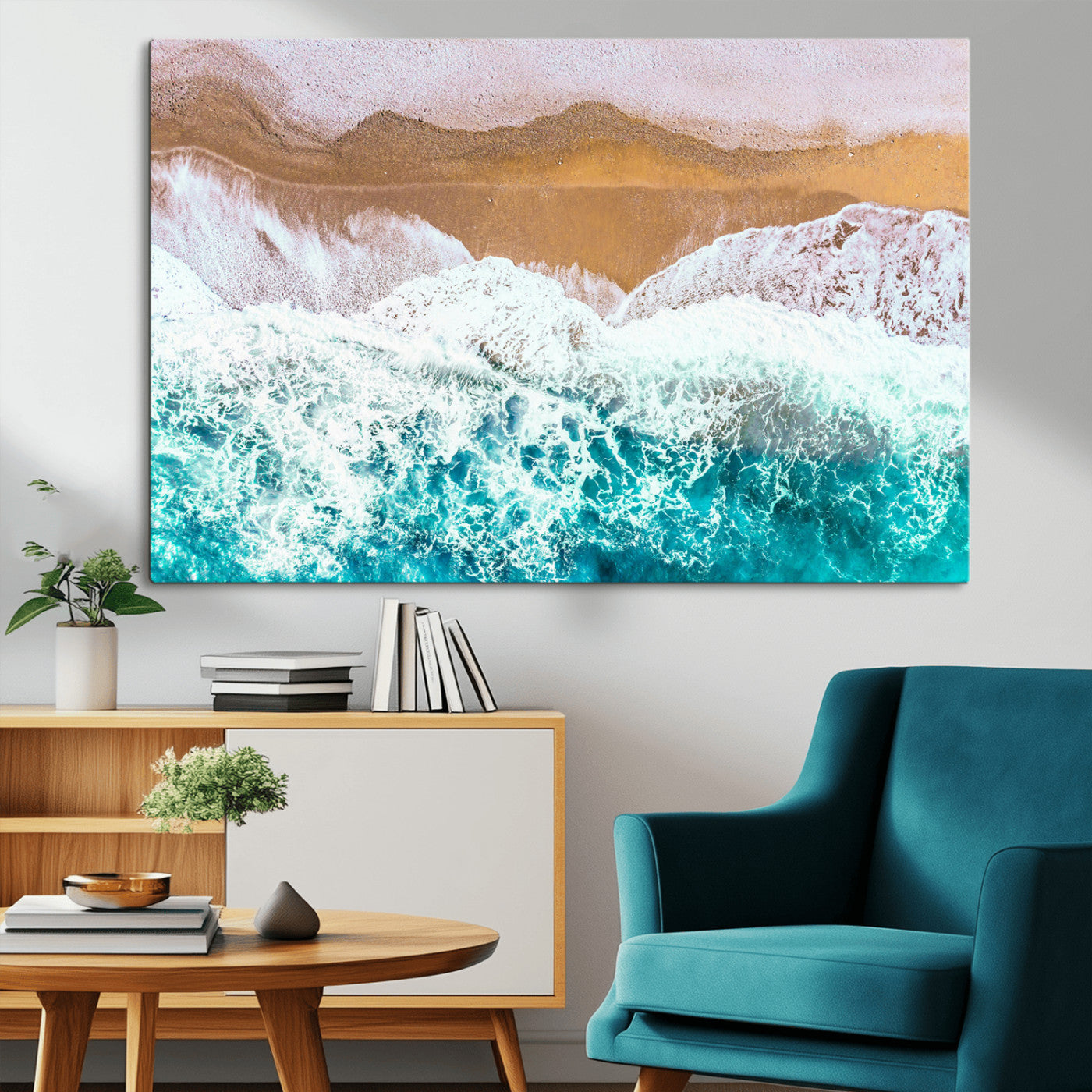 Aerial view of ocean waves crashing onto a sandy beach, with turquoise water and foamy white surf, creating a serene coastal aesthetic for home decor.