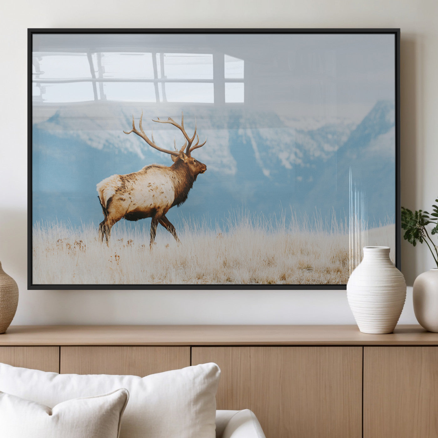 Majestic elk with antlers walking on golden grass, snowy mountains behind, perfect for rustic lodge or Scandinavian decor.