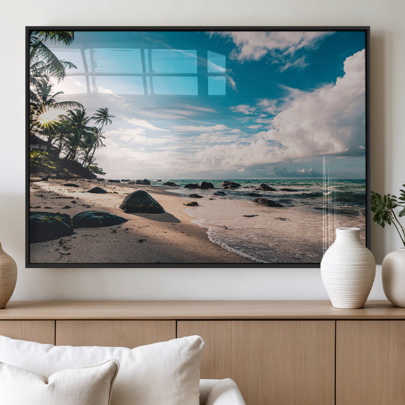 Scenic tropical beach with palm trees, ocean waves, and rocky shoreline under a bright blue sky, creating a serene coastal vibe.