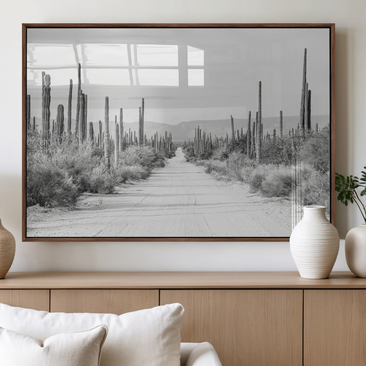 A black and white desert road stretching through a cactus-filled landscape, creating a rugged and timeless southwestern aesthetic with a sense of adventure.