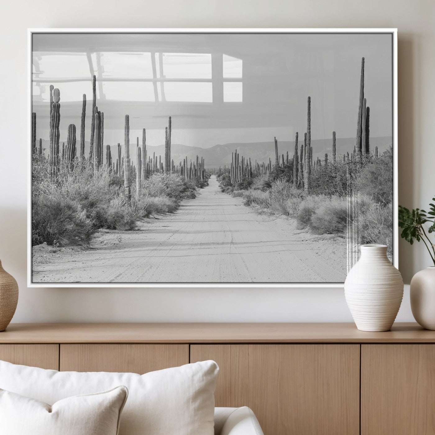A black and white desert road stretching through a cactus-filled landscape, creating a rugged and timeless southwestern aesthetic with a sense of adventure.