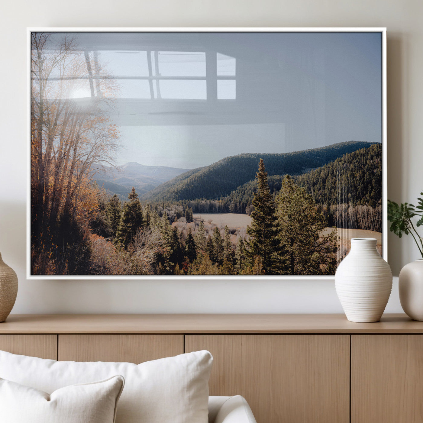 A scenic mountain valley with pine trees and autumn foliage under a clear sky, bathed in golden sunlight, creating a peaceful and rustic landscape.