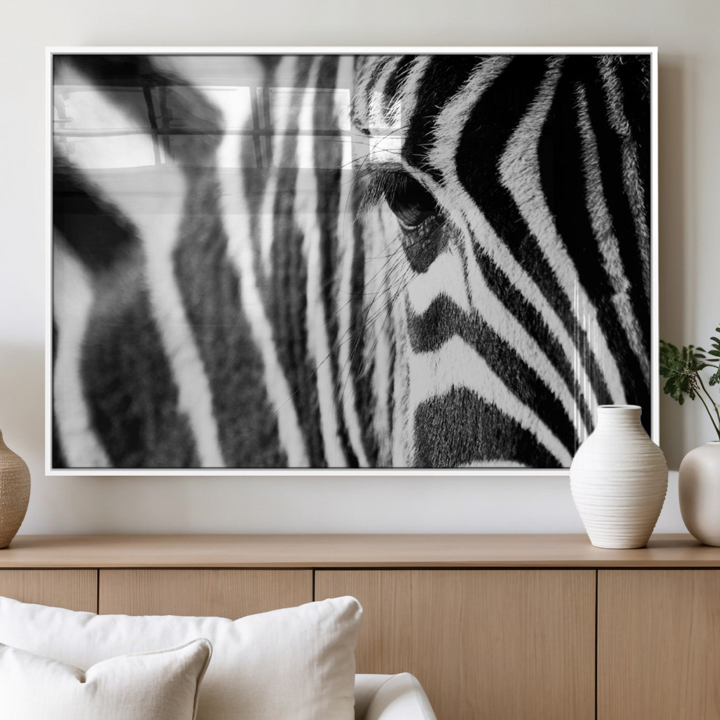 A close-up black and white photograph of a zebra's eye, showcasing the intricate patterns of its stripes in sharp detail.