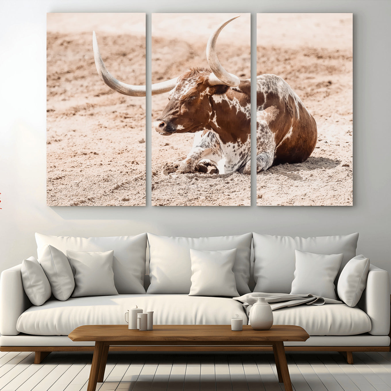 Texas Longhorn bull resting on dusty ground with warm tones, ideal for rustic western or farmhouse-themed wall decor.