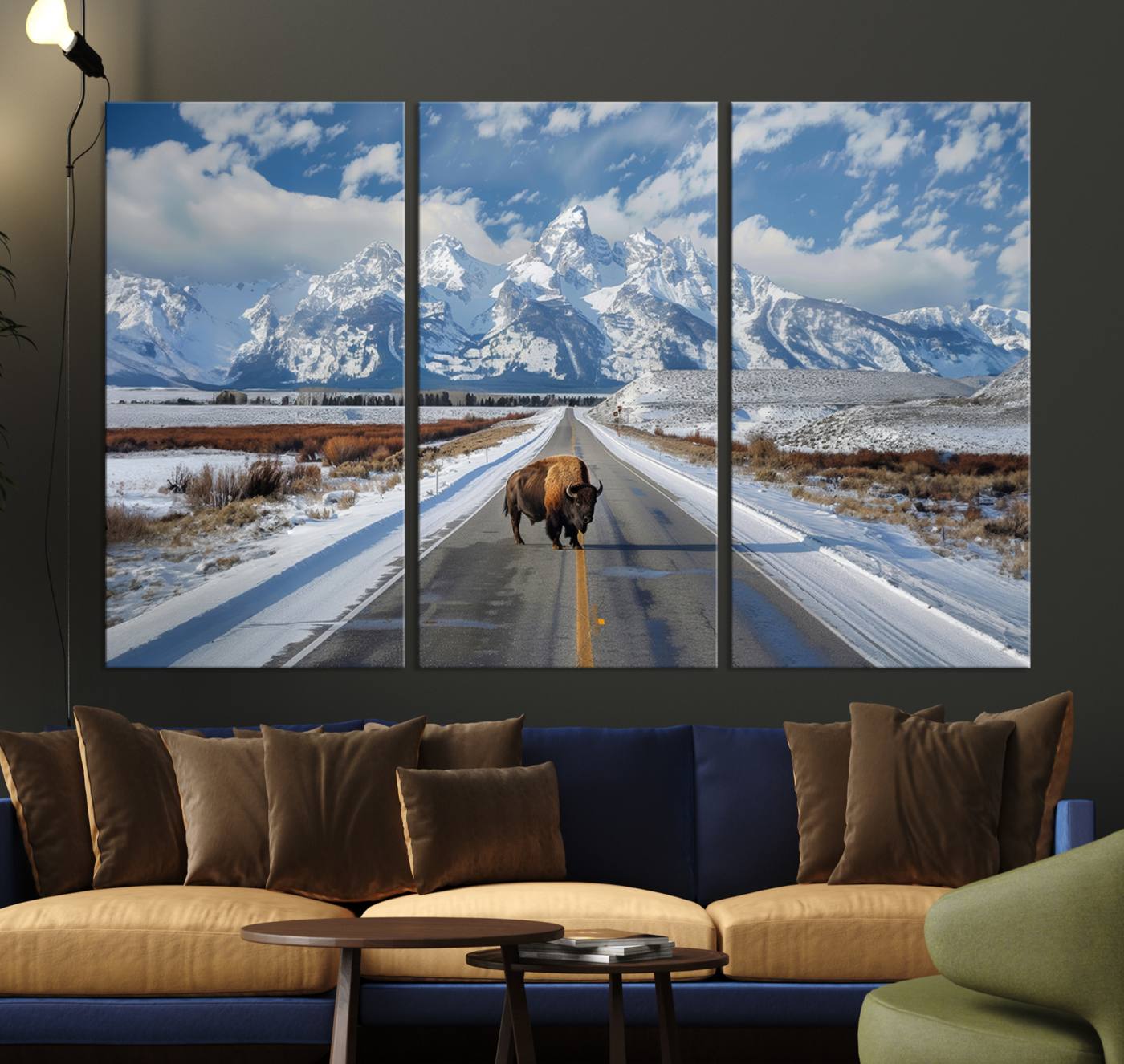 A powerful bison stands on a snow-dusted road beneath the towering peaks of the Grand Tetons, capturing the untamed beauty of America's winter wilderness.