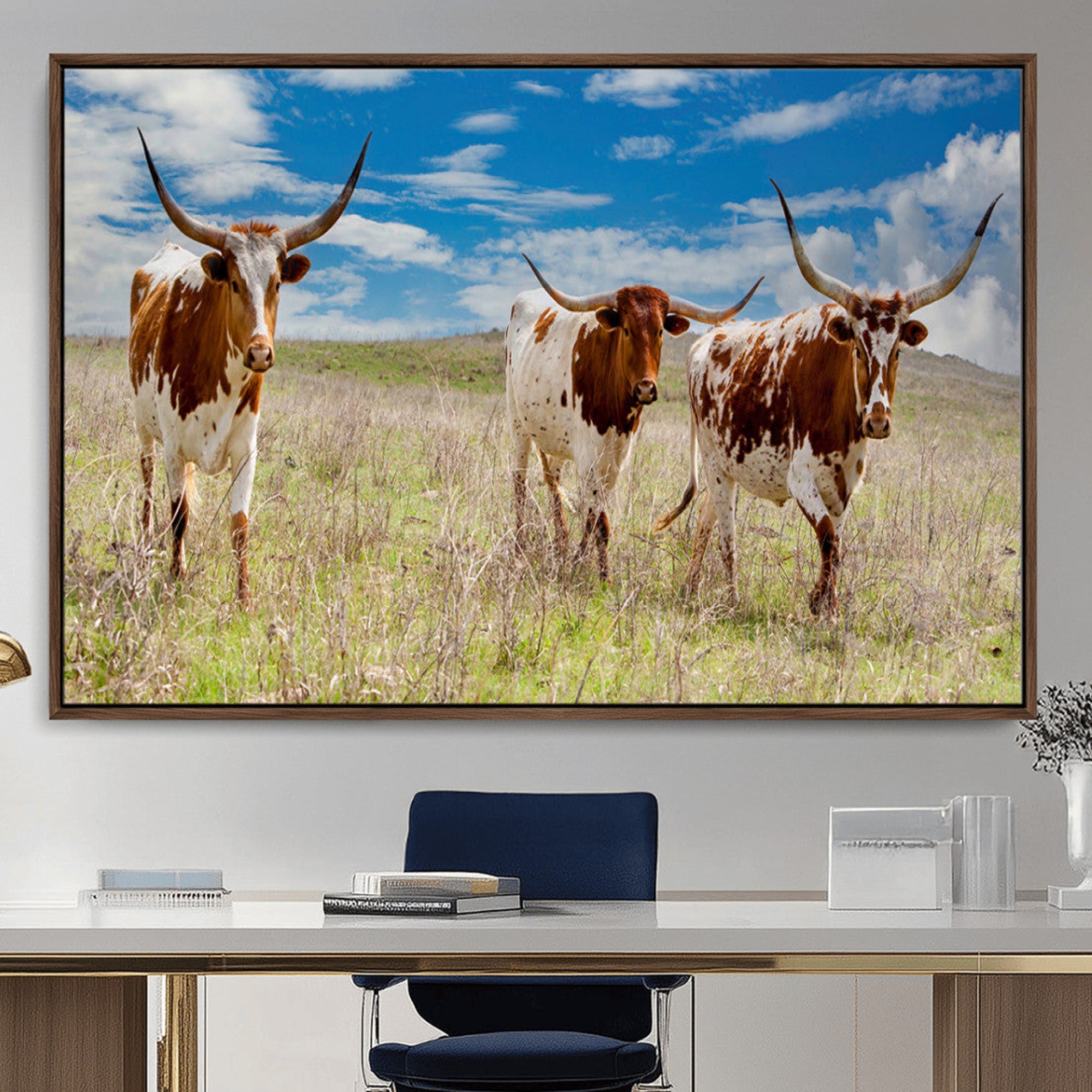 Three Texas longhorn cattle standing in dry grass under a bright blue sky, ideal for farmhouse or western rustic home decor.