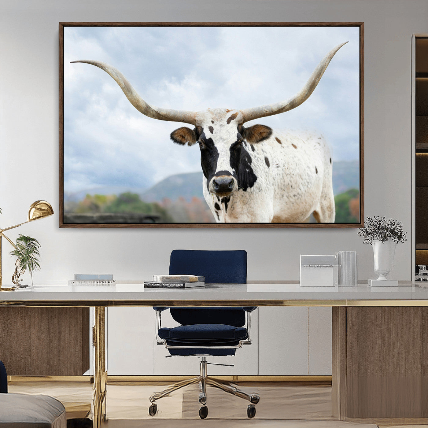 Close-up of a Texas Longhorn with curved horns, black and white markings, set against a cloudy sky and distant hills, perfect for rustic decor.