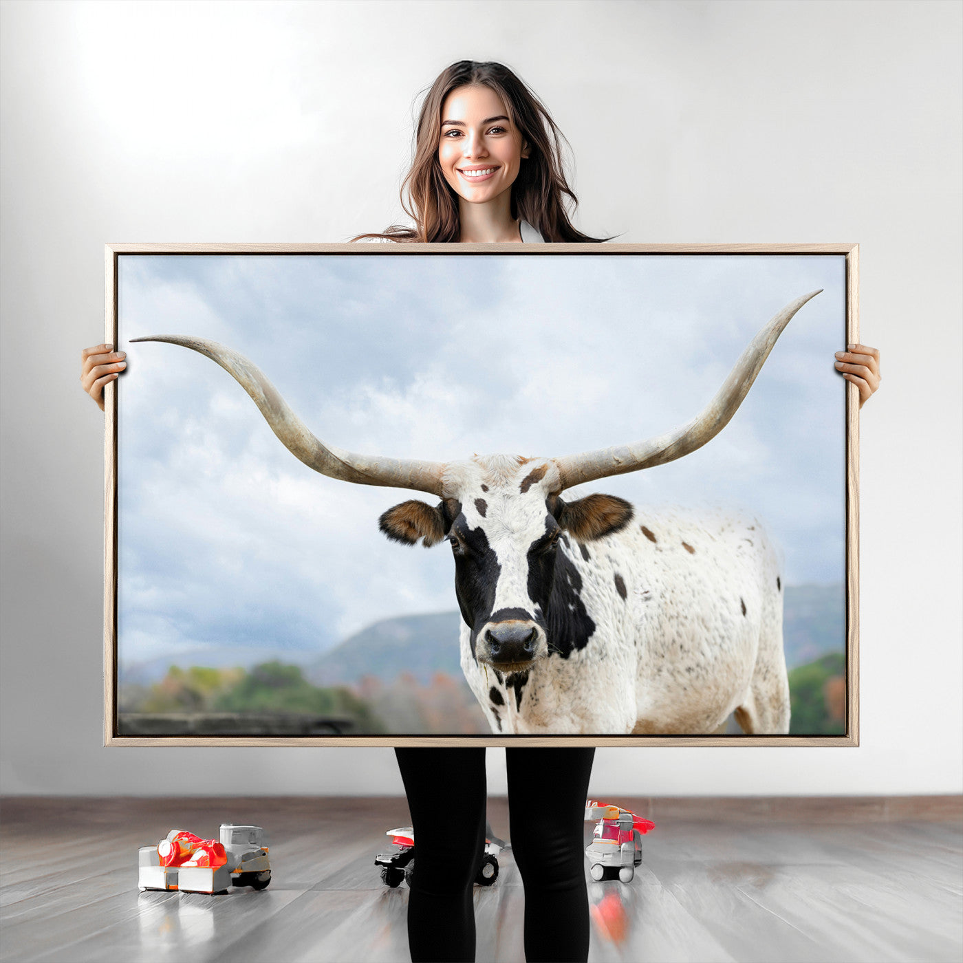 Close-up of a Texas Longhorn with curved horns, black and white markings, set against a cloudy sky and distant hills, perfect for rustic decor.