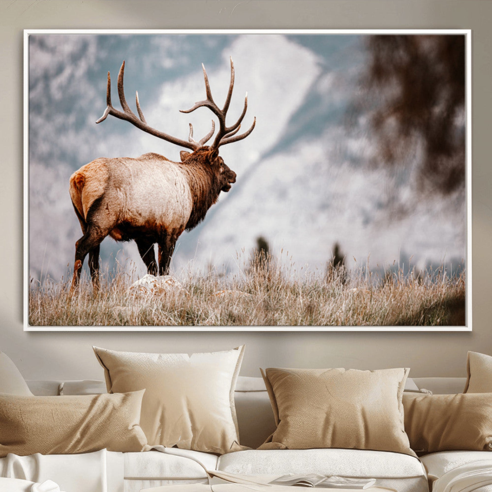 Majestic elk with large antlers standing in grass with snowy mountains in background, perfect for rustic cabin or lodge style decor.