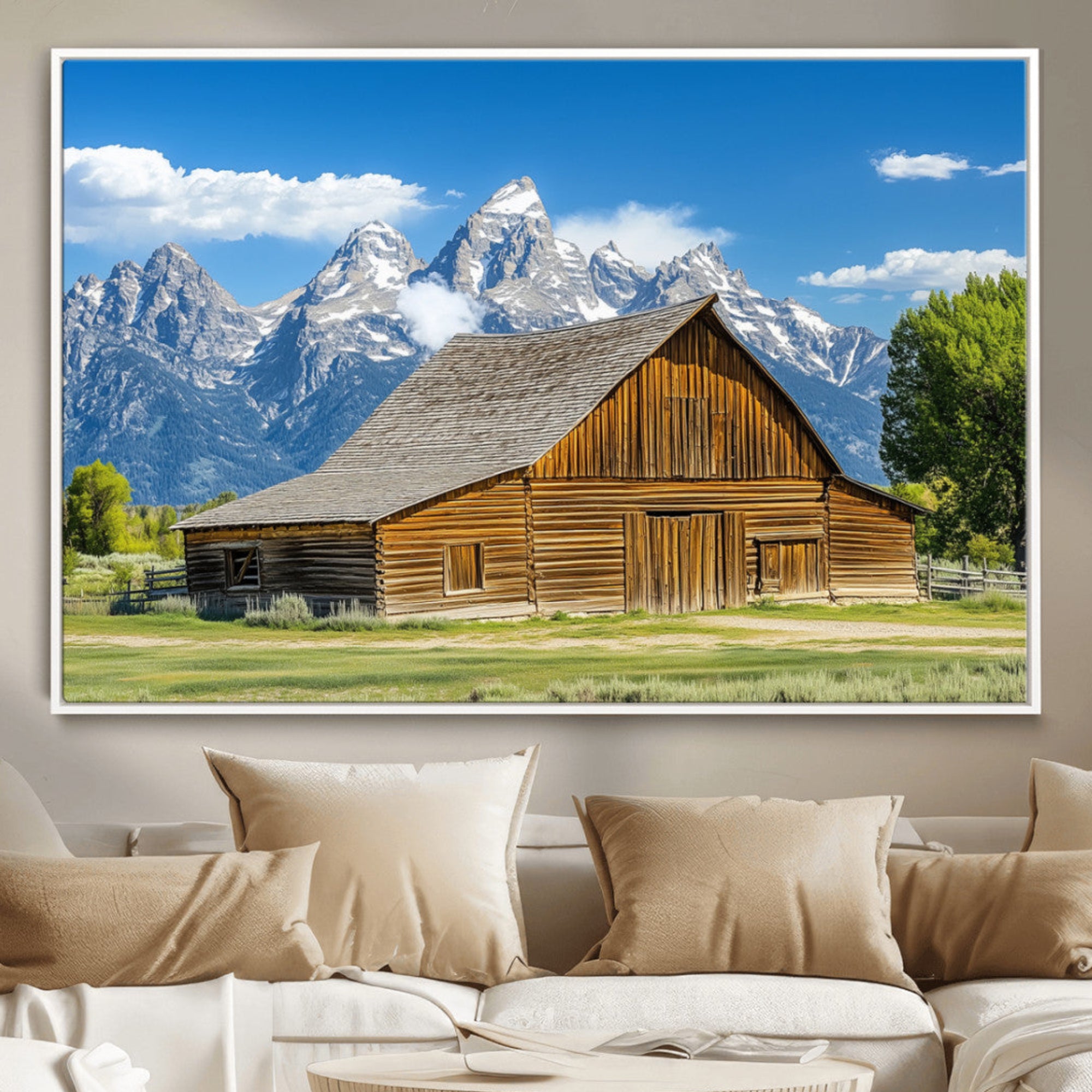 A rustic wooden barn sits in front of towering mountain peaks under a clear blue sky, perfect for farmhouse or cabin style interiors.