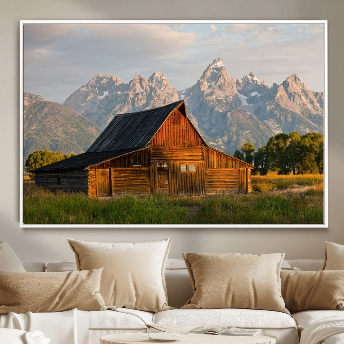 Rustic wooden barn set against towering mountain peaks under warm golden light, creating a peaceful Western countryside scene.