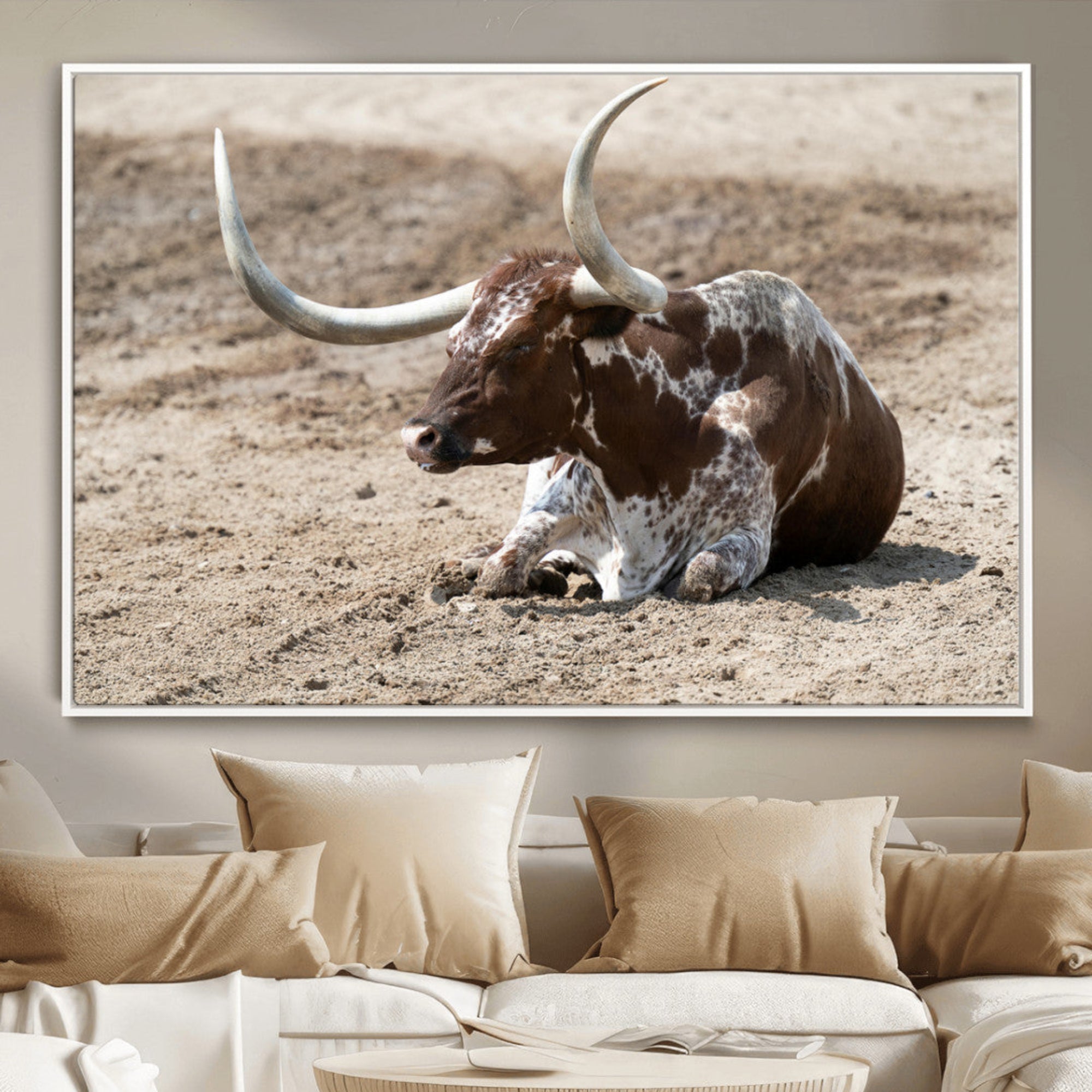 Texas Longhorn resting on sandy ground with large curved horns, capturing a rustic Western aesthetic perfect for farmhouse-style wall art.