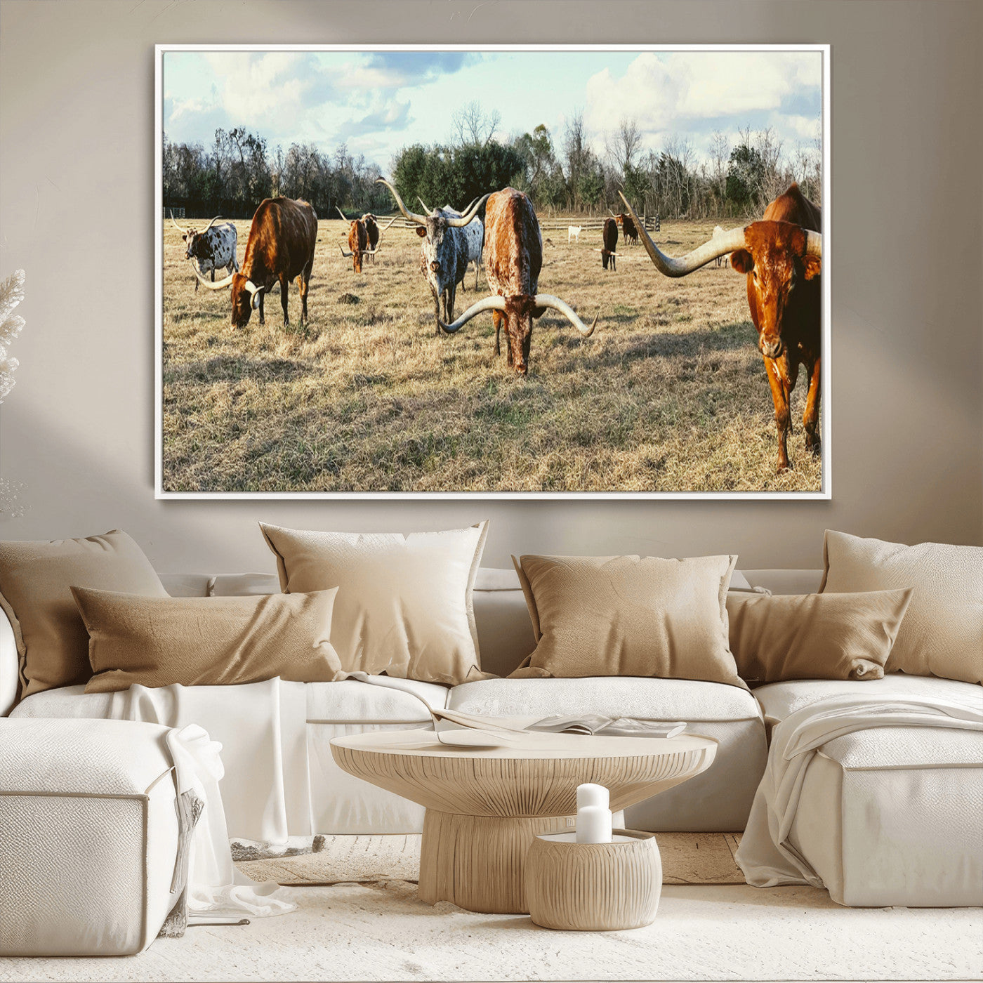 A herd of Texas Longhorn cattle grazing in an open field under a partly cloudy sky, capturing a rustic and Western ranch aesthetic.