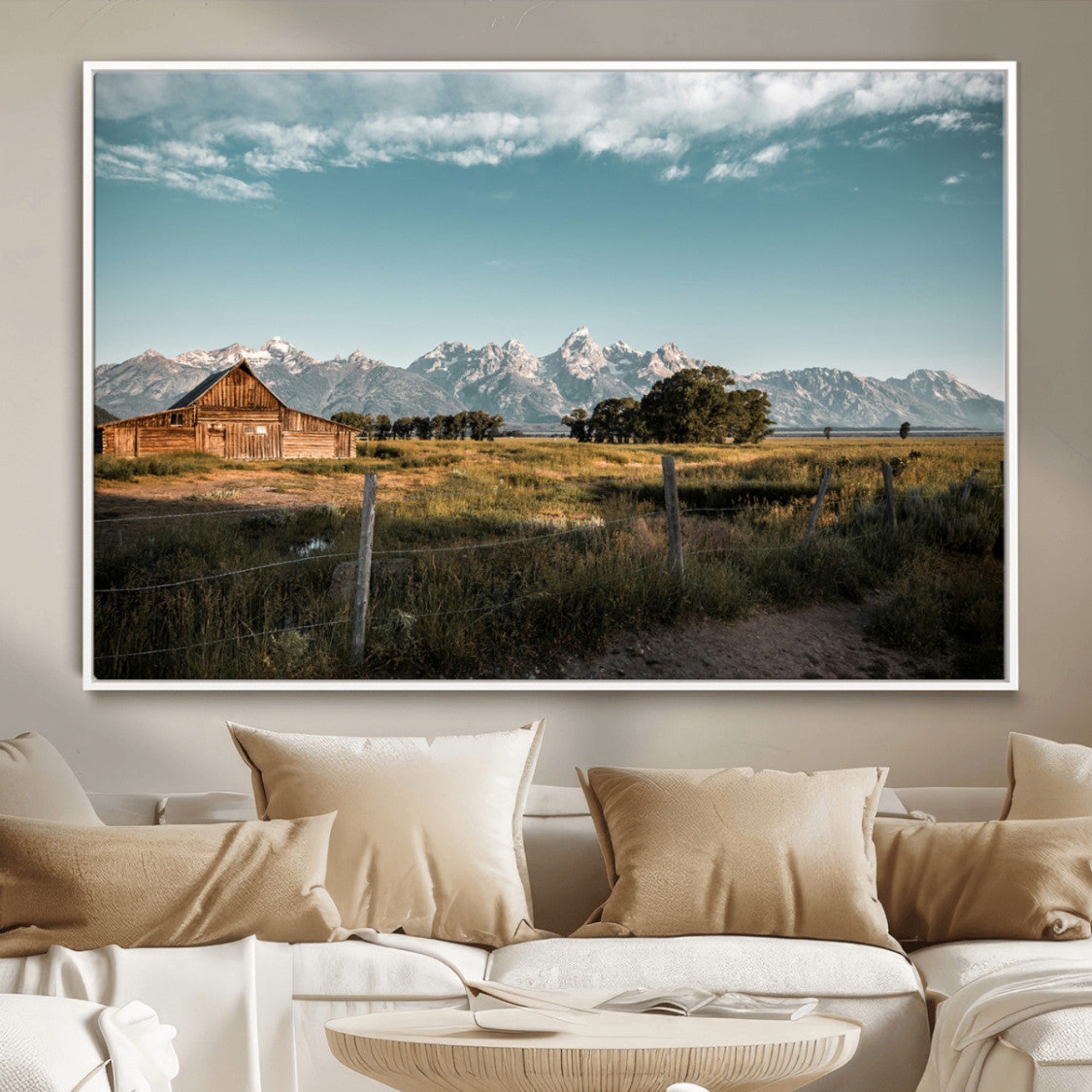 A rustic farmhouse with a wooden barn set against majestic mountain peaks under a soft blue sky, evoking peaceful countryside charm.