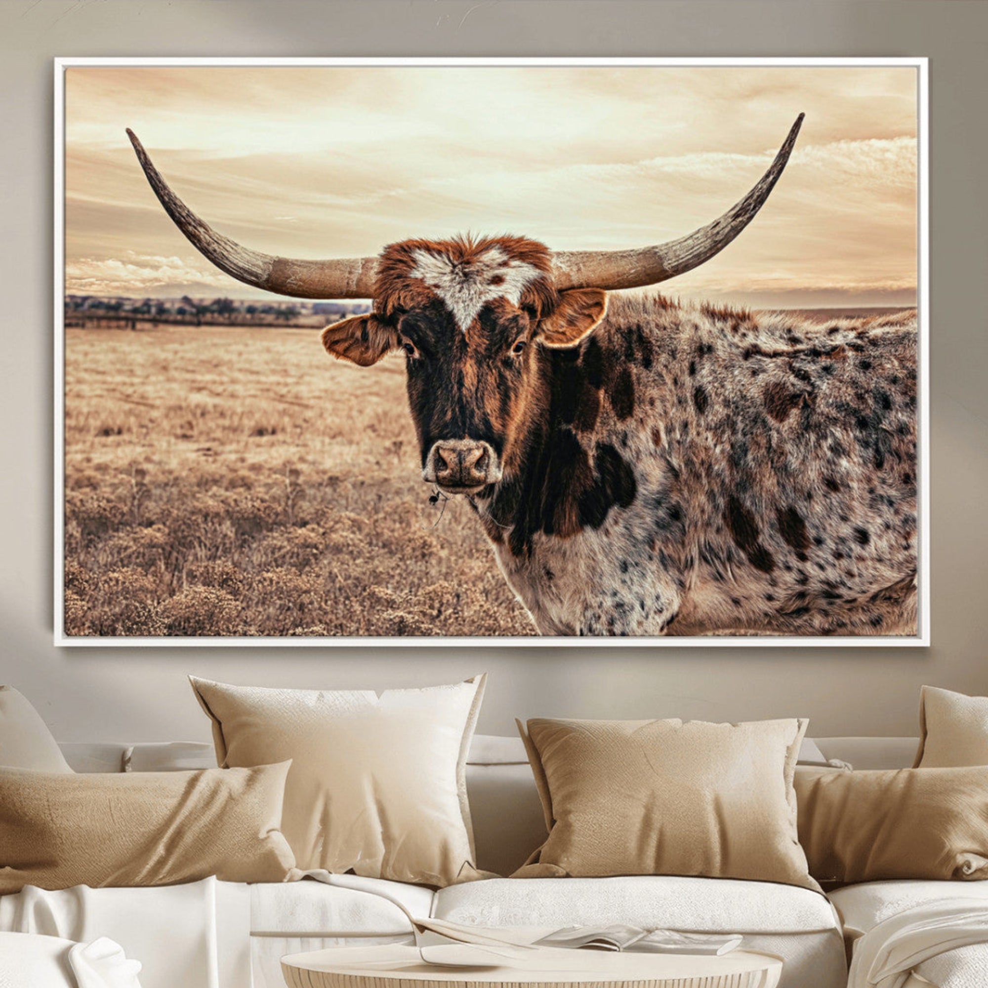 Close-up of a longhorn cow with distinctive curved horns standing in a dry grass field under a cloudy sky.