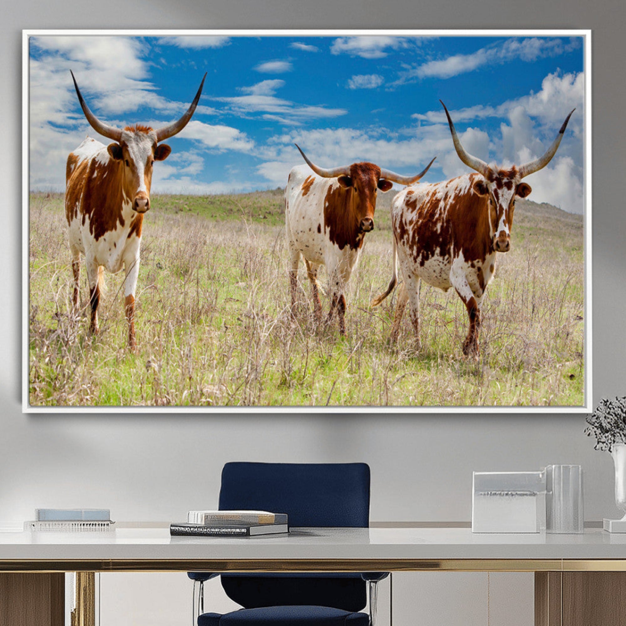 Three Texas longhorn cattle standing in dry grass under a bright blue sky, ideal for farmhouse or western rustic home decor.