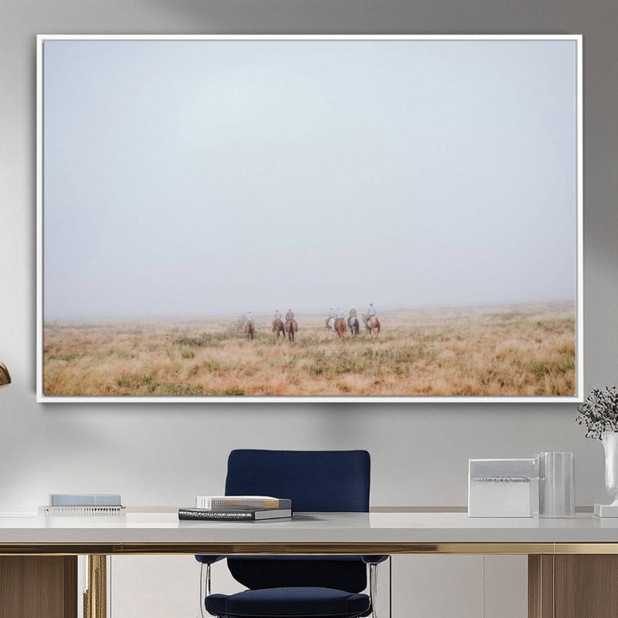 A group of horseback riders moving through a fog-shrouded field, evoking a calm Western scene with golden grasses and soft horizons.