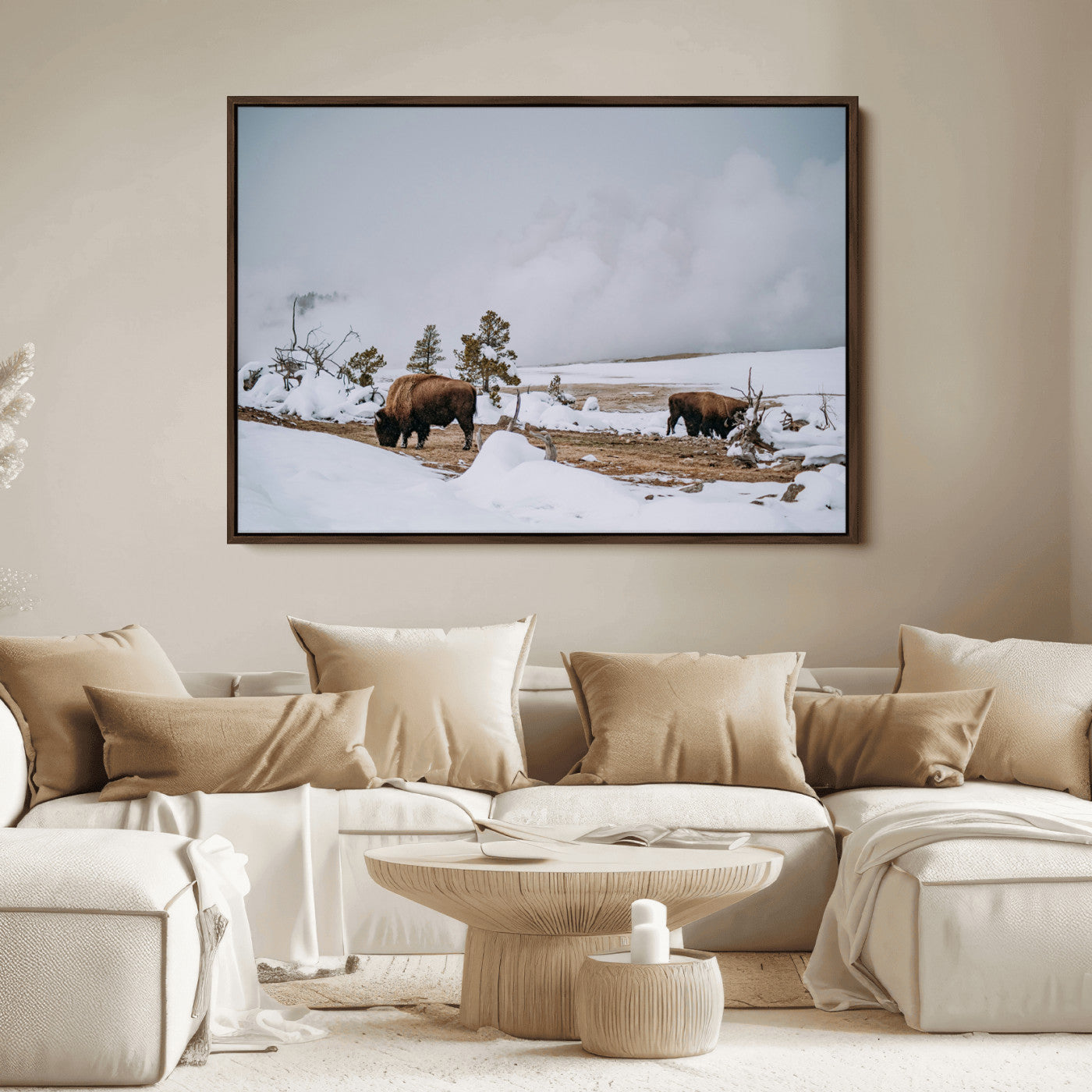Two bison grazing in a snowy open landscape with misty hills in the background, creating a peaceful and rustic winter scene.