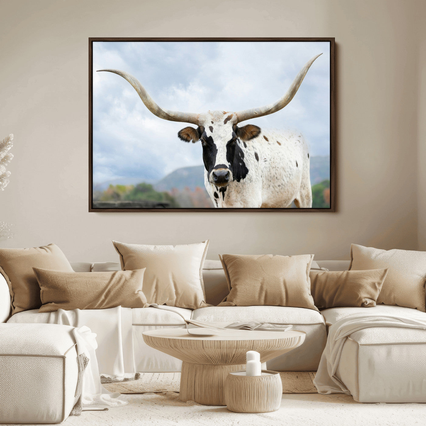 Close-up of a Texas Longhorn with curved horns, black and white markings, set against a cloudy sky and distant hills, perfect for rustic decor.