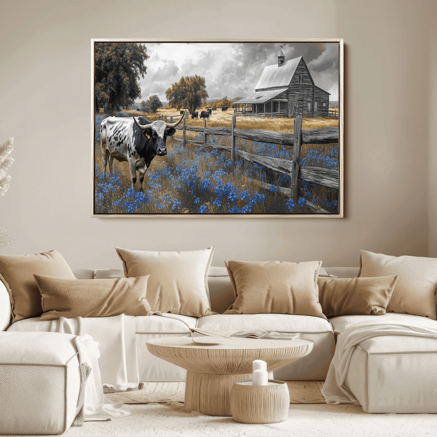 A Texas longhorn stands in front of a rustic barn and wooden fence, with bluebonnets and grazing cattle under dramatic skies.