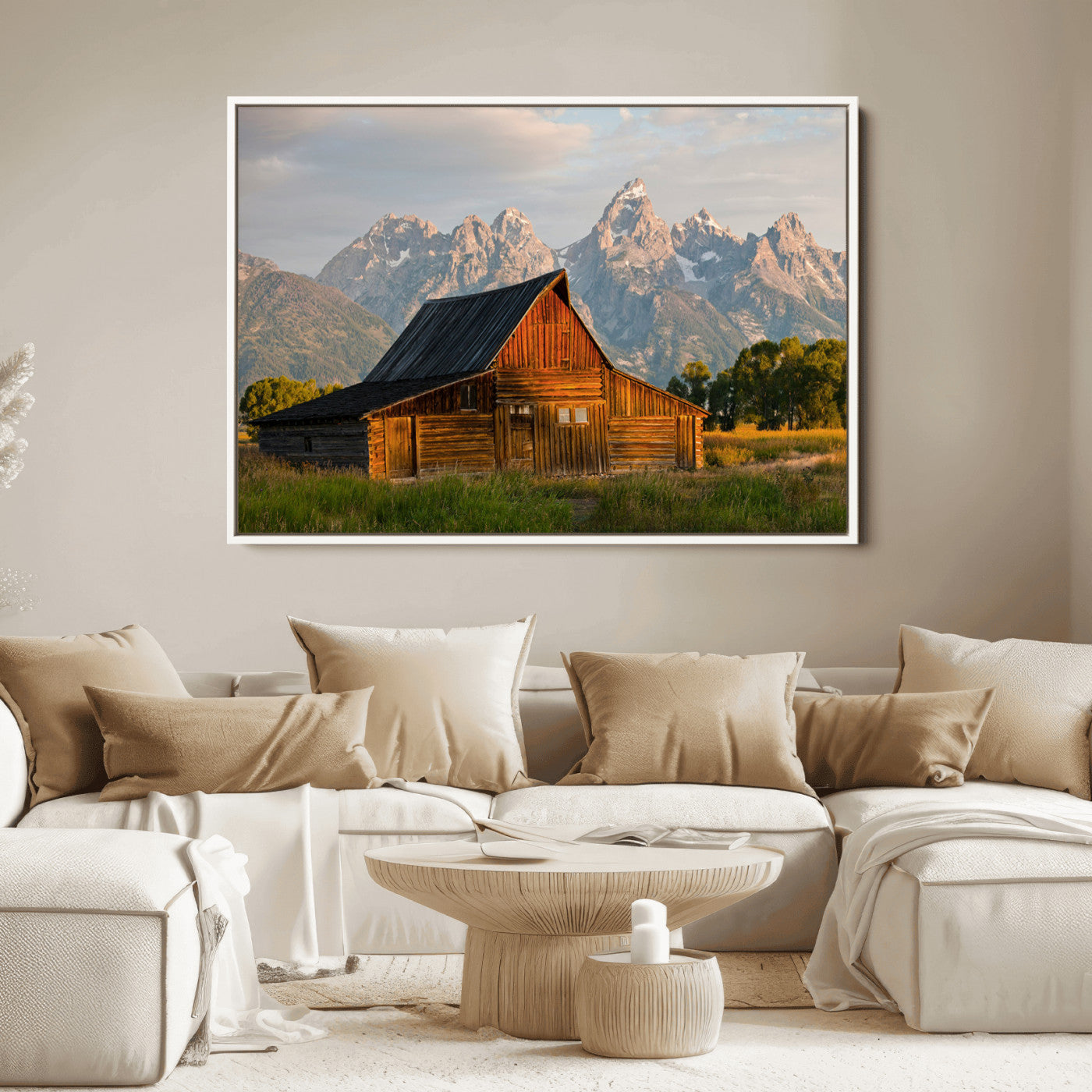Rustic wooden barn set against towering mountain peaks under warm golden light, creating a peaceful Western countryside scene.